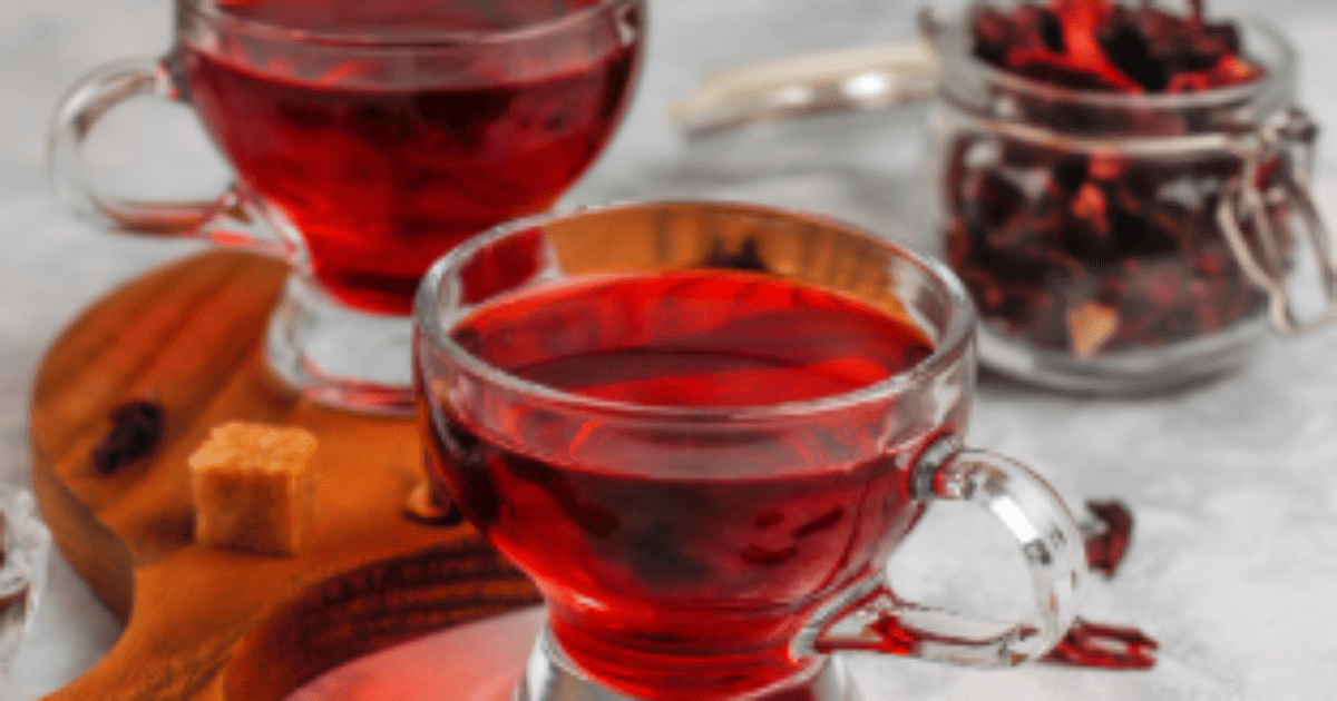 Copo de chá de hibisco com flores secas ao fundo