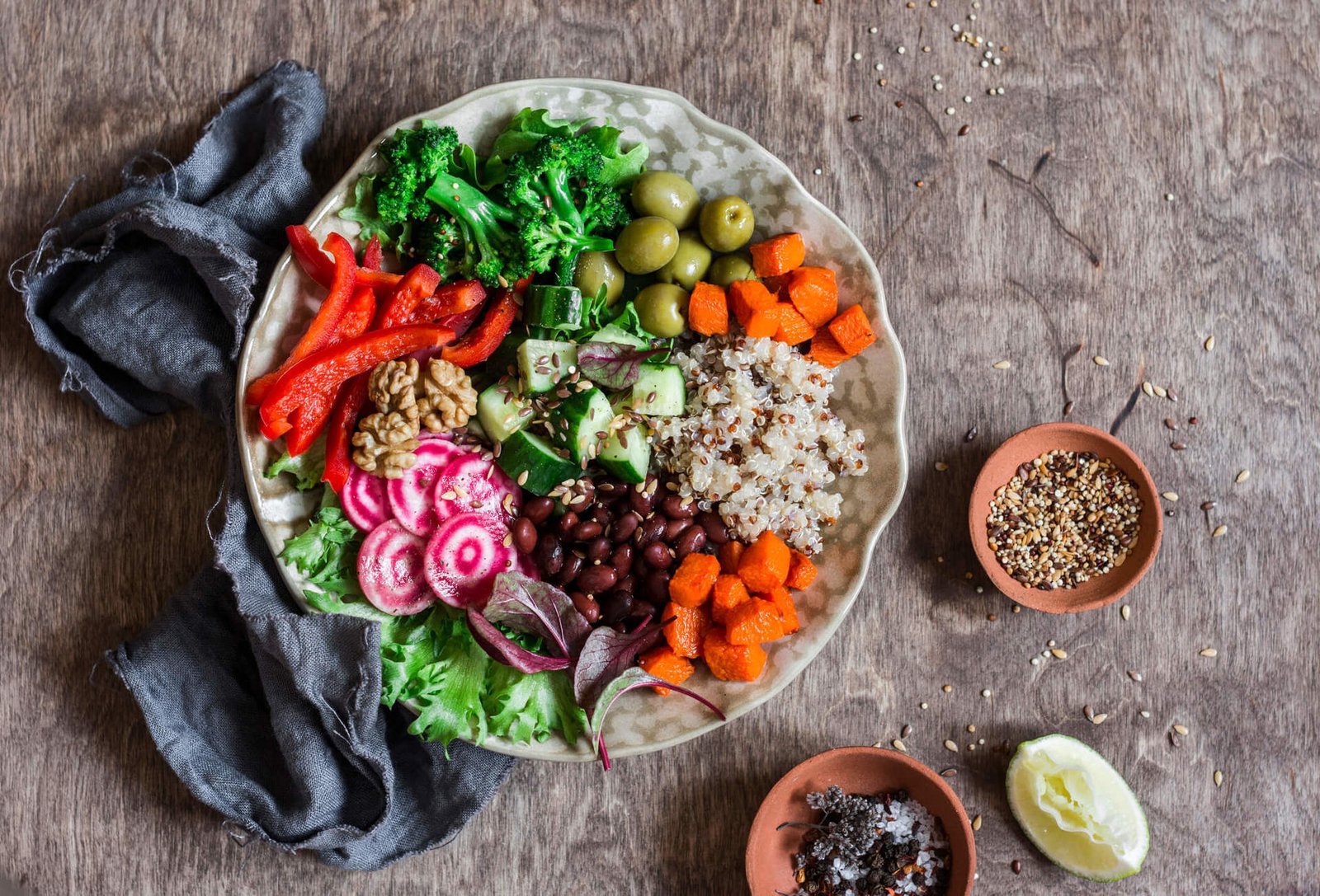 Prato colorido com diversos alimentos vegetais, incluindo frutas, legumes, grãos e nozes, representando a dieta plant-based.